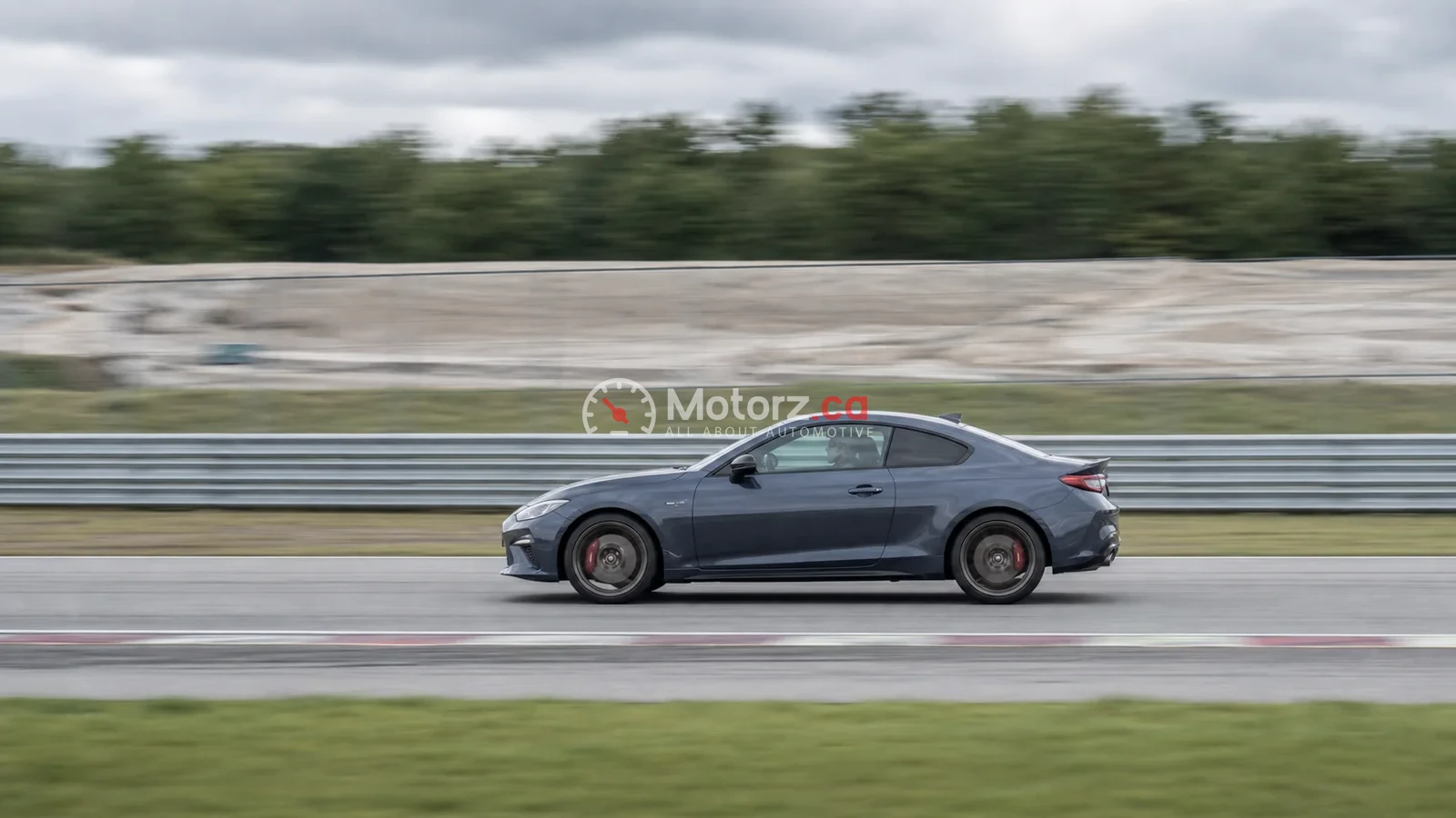 Conceptual panning image of an unbranded car moving on a closed track with a blurred background.